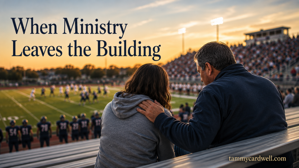 Pastor placing a comforting hand on a woman's shoulder during a football game, illustrating how ministry happens beyond the church building.